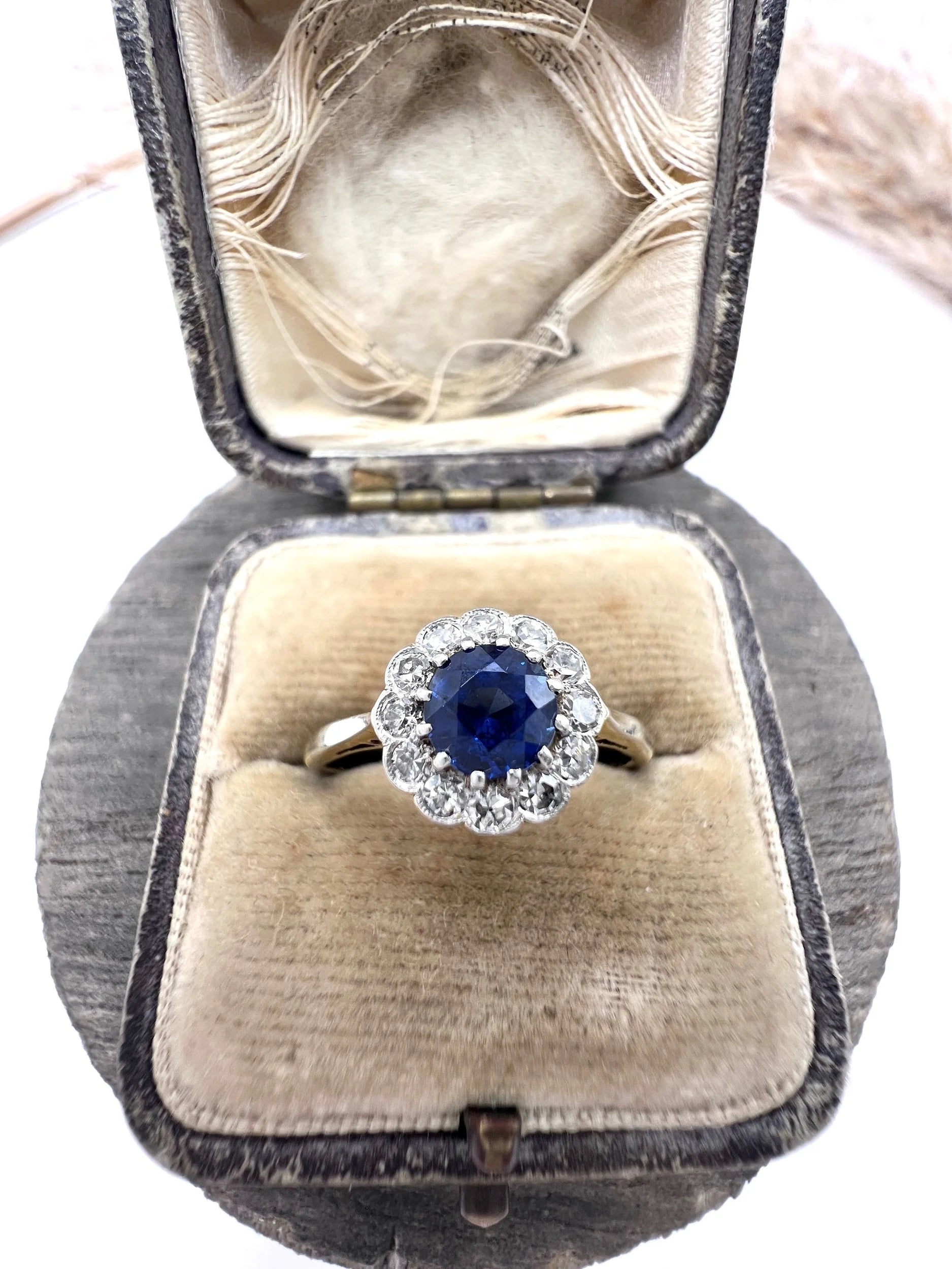 A sapphire and diamond flower cluster ring in yellow gold and platinum, in a ring box