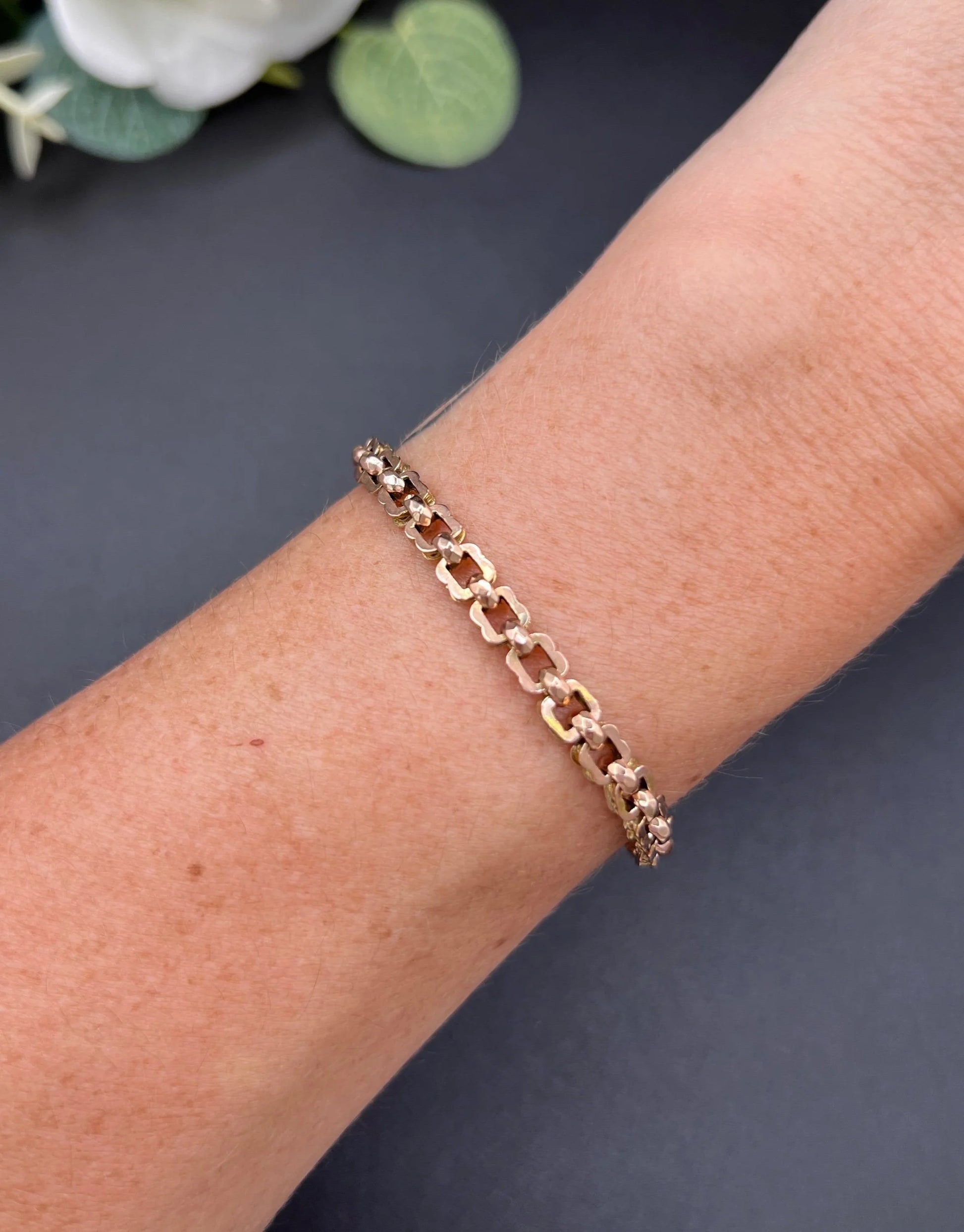 A fancy link rose gold bracelet, modelled on a wrist