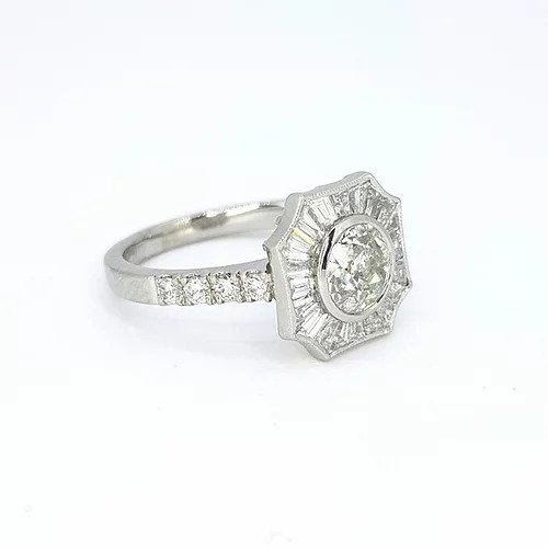 Old Cut Diamond Cluster Target Ring; central 0.69 carat old cut diamond surrounded by calibre cut diamonds, diamond set shoulders, in 18ct white gold