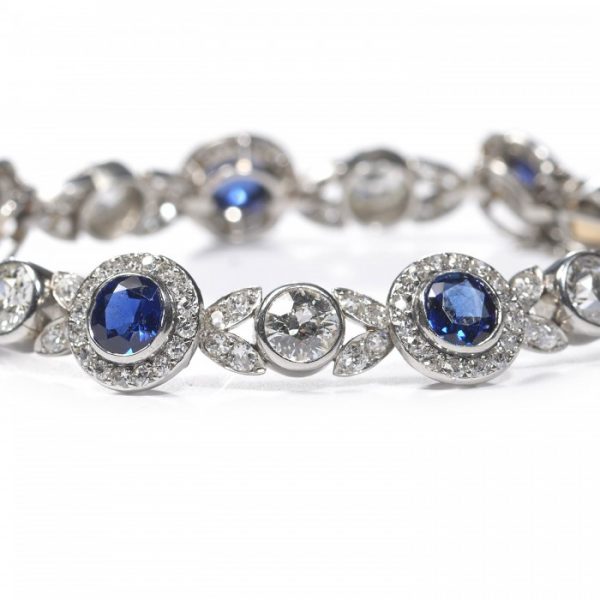 Belle Epoque Burmese Sapphire and Old Cut Diamond Bracelet in Platinum; comprised of round Burmese sapphire and diamond clusters, connected by diamond-set leaf motifs with a round old-cut diamond between each. Circa 1900. Sapphires 5.25 carats, Diamonds 9.50 carats