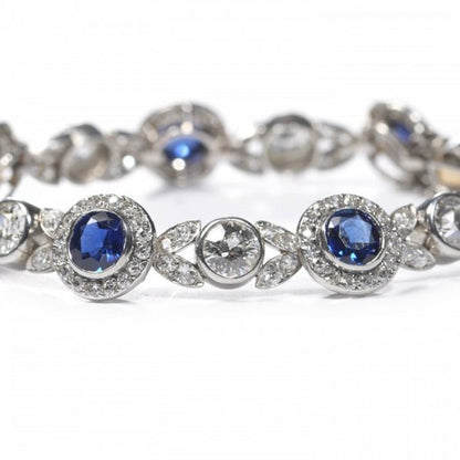 Belle Epoque Burmese Sapphire and Old Cut Diamond Bracelet in Platinum; comprised of round Burmese sapphire and diamond clusters, connected by diamond-set leaf motifs with a round old-cut diamond between each. Circa 1900. Sapphires 5.25 carats, Diamonds 9.50 carats