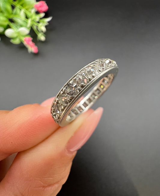 A platinum full eternity ring with round diamonds, held in a hand