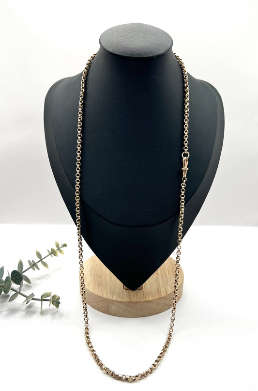 A gold rolo link chain necklace with swivel clasp, on a black bust