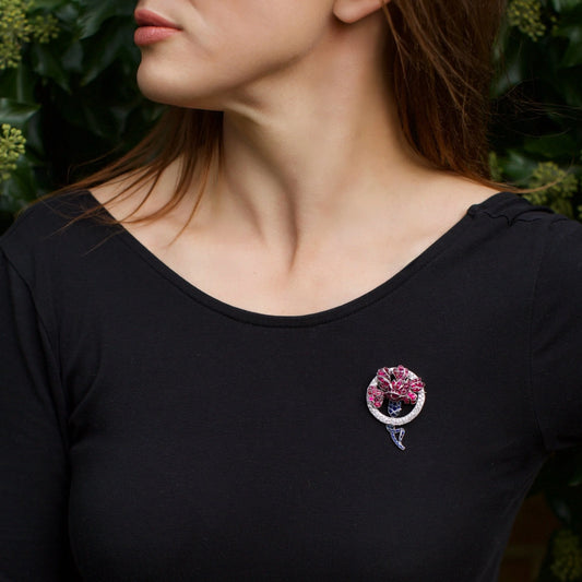A ruby, sapphire and diamond decorative brooch in platinum, modelled on a woman's black top