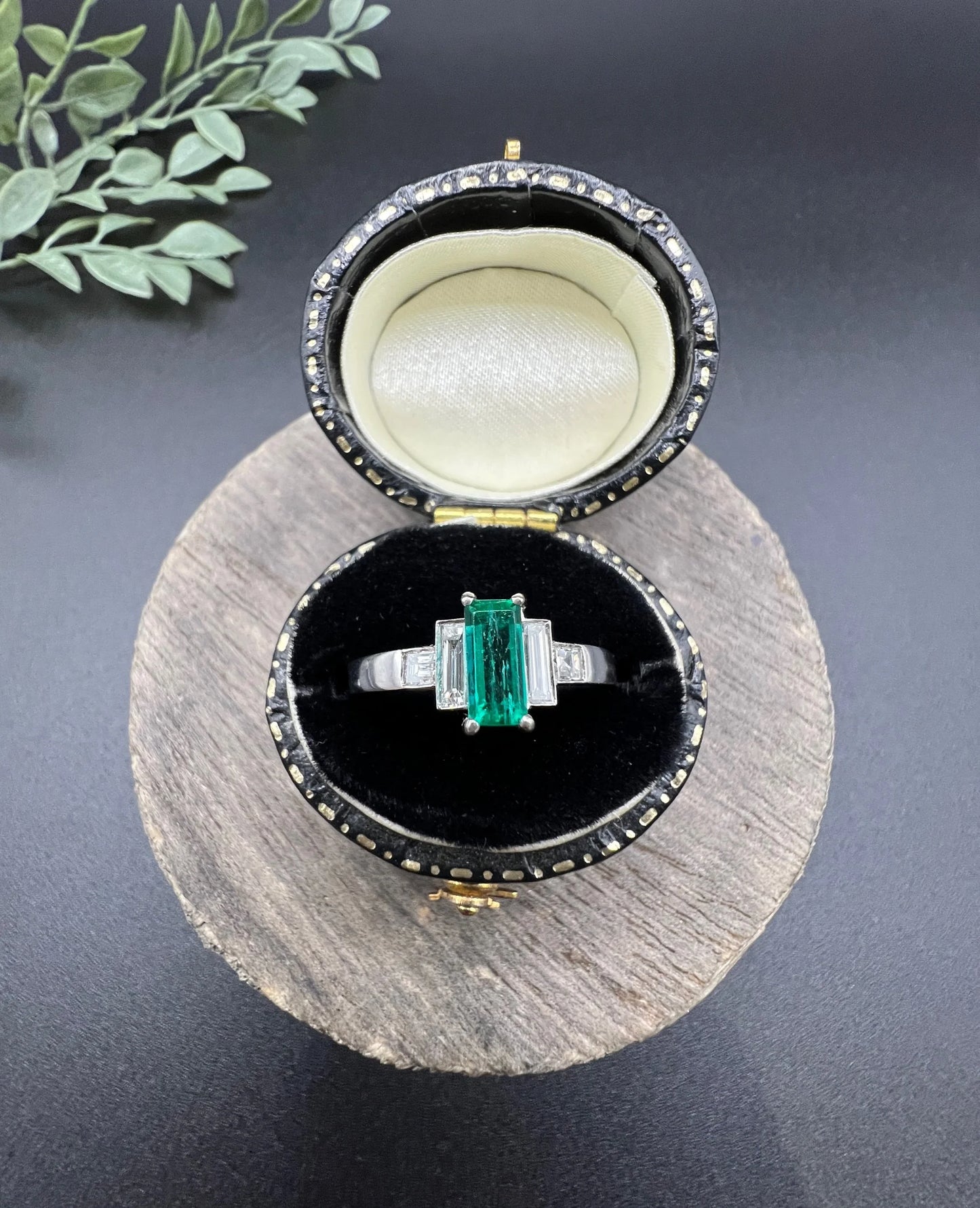 A five stone emerald cut emerald and baguette and square cut diamond ring in platinum, in a ring box