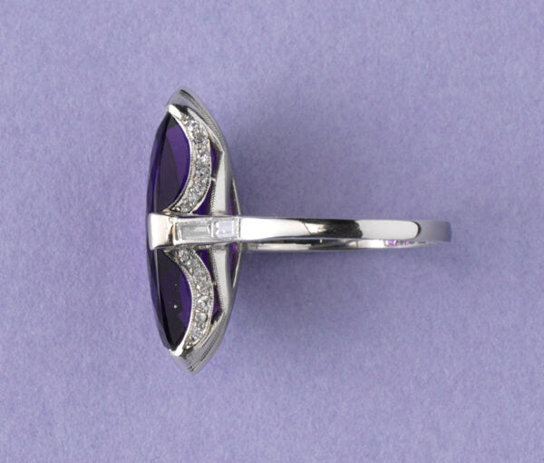 Art Deco Marquise Cut Amethyst, Diamond and Platinum Cocktail Ring; featuring a deep purple navette cut amethyst with brilliant-cut diamond set arches and baguette-cut diamond set shoulders