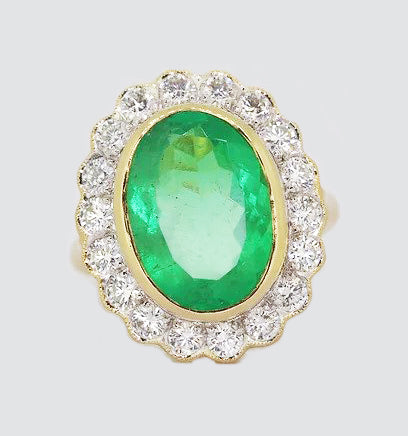 5.14ct Emerald and Diamond Oval Cluster Ring; featuring a 5.14 carat oval-cut emerald surrounded by 1.26 carats of diamonds. Collet-set in 18ct yellow gold.
