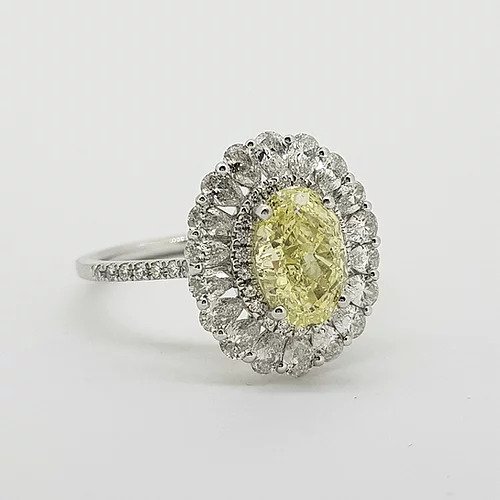 Fancy Yellow Diamond Cluster Ring with GIA Certificate; 1.59ct Oval Fancy Yellow GIA certified Natural Diamond surrounded by 0.15cts brilliant white diamonds and an outer border of 0.90cts pear-shaped diamonds, giving a scalloped edge finish, mounted in platinum