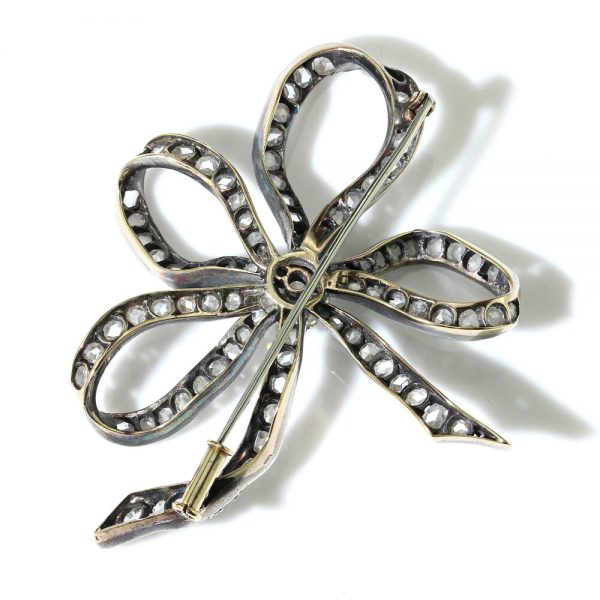 Antique Old Cut Diamond Bow Brooch; set with 6.55 carats of old-cut and rose-cut diamonds, in silver and 15ct gold, Circa 1830s