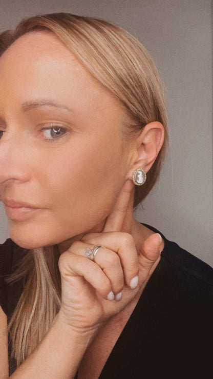 A yellow gold oval shell cameo earring, modelled in an ear