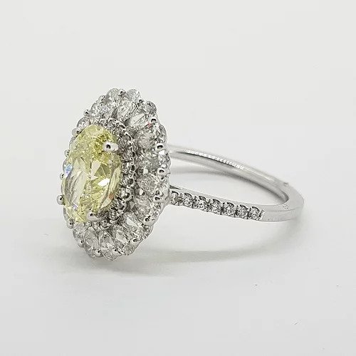 Fancy Yellow Diamond Cluster Ring with GIA Certificate; 1.59ct Oval Fancy Yellow GIA certified Natural Diamond surrounded by 0.15cts brilliant white diamonds and an outer border of 0.90cts pear-shaped diamonds, giving a scalloped edge finish, mounted in platinum