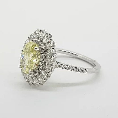 Fancy Yellow Diamond Cluster Ring with GIA Certificate; 1.59ct Oval Fancy Yellow GIA certified Natural Diamond surrounded by 0.15cts brilliant white diamonds and an outer border of 0.90cts pear-shaped diamonds, giving a scalloped edge finish, mounted in platinum