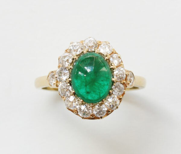 Antique Edwardian Oval Cabochon Emerald and Diamond Cluster Ring; 2.70ct oval cabochon cut emerald surrounded by 1.65cts old-cut diamonds, 18ct yellow gold