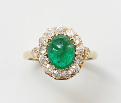 Antique Edwardian Oval Cabochon Emerald and Diamond Cluster Ring; 2.70ct oval cabochon cut emerald surrounded by 1.65cts old-cut diamonds, 18ct yellow gold