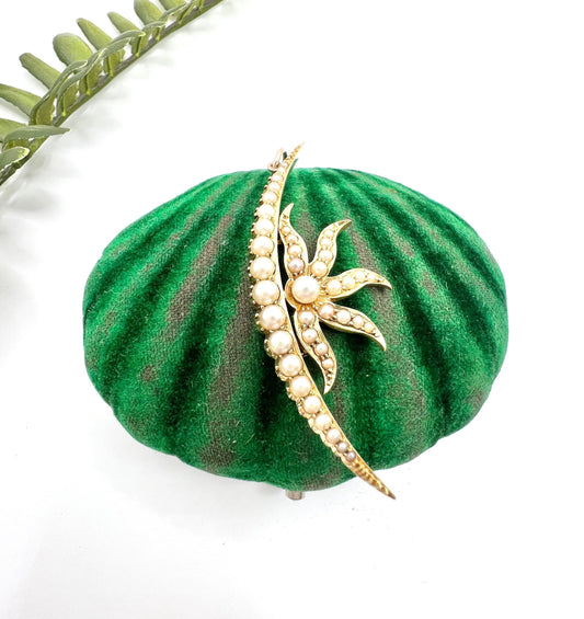 A yellow gold pearl set cresent and sunburst pendant