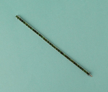 Art Deco Tourmaline Line Bracelet in Platinum; set with 34 baguette step-cut green tourmalines, Circa 1920