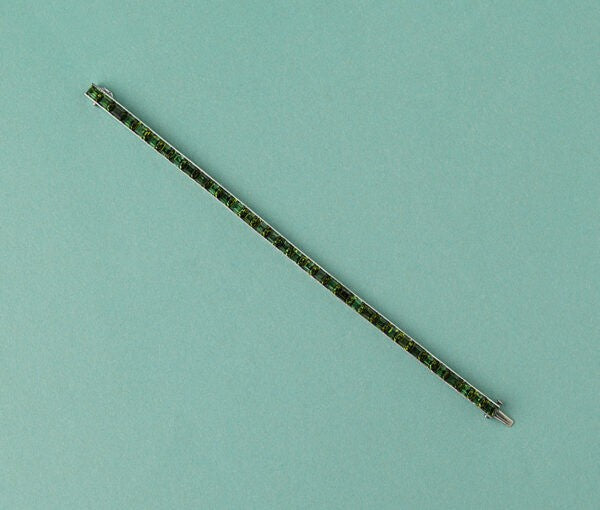 Art Deco Tourmaline Line Bracelet in Platinum; set with 34 baguette step-cut green tourmalines, Circa 1920