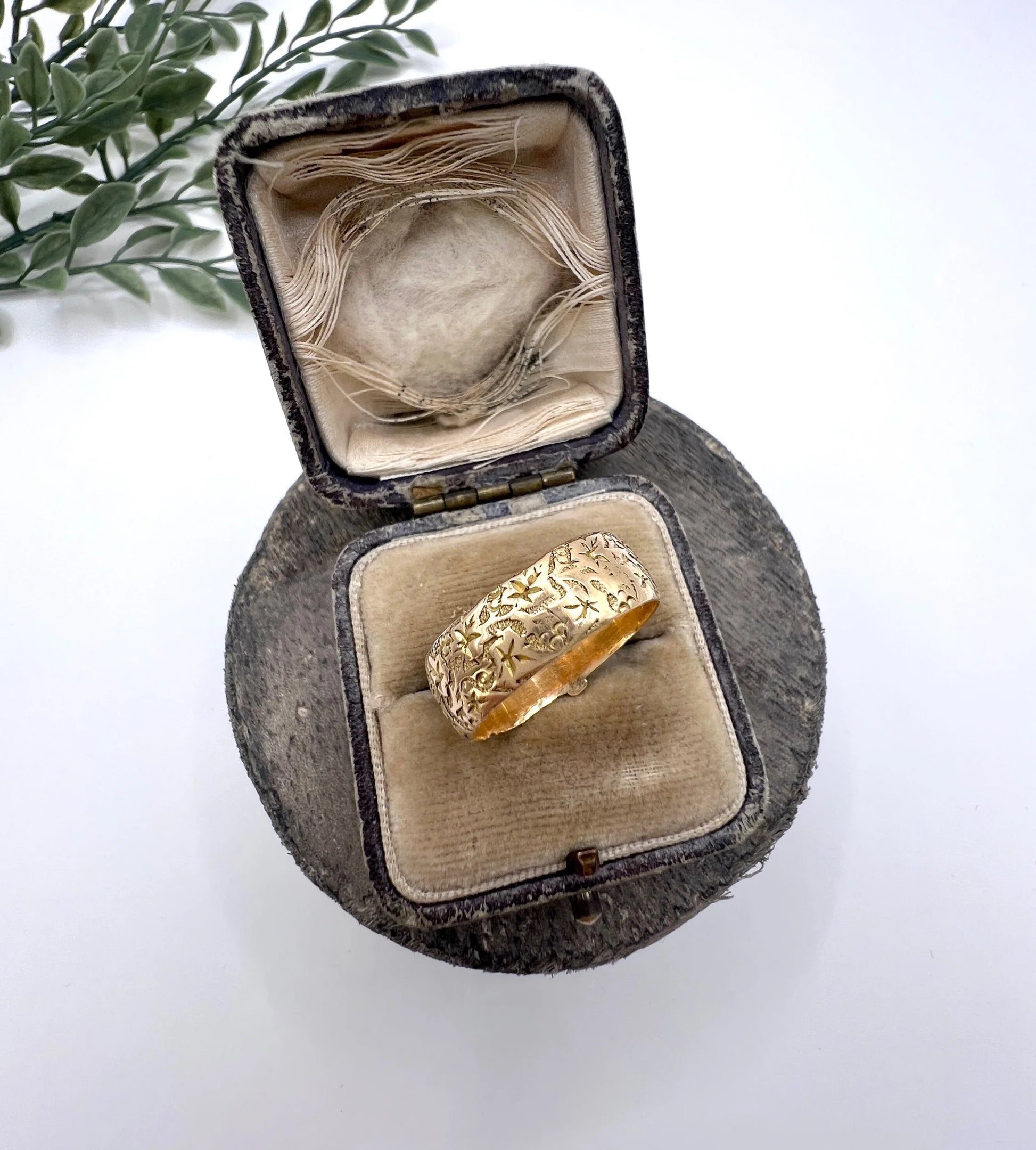 A yellow gold ornate engraved buckle band ring, in an antique ring box