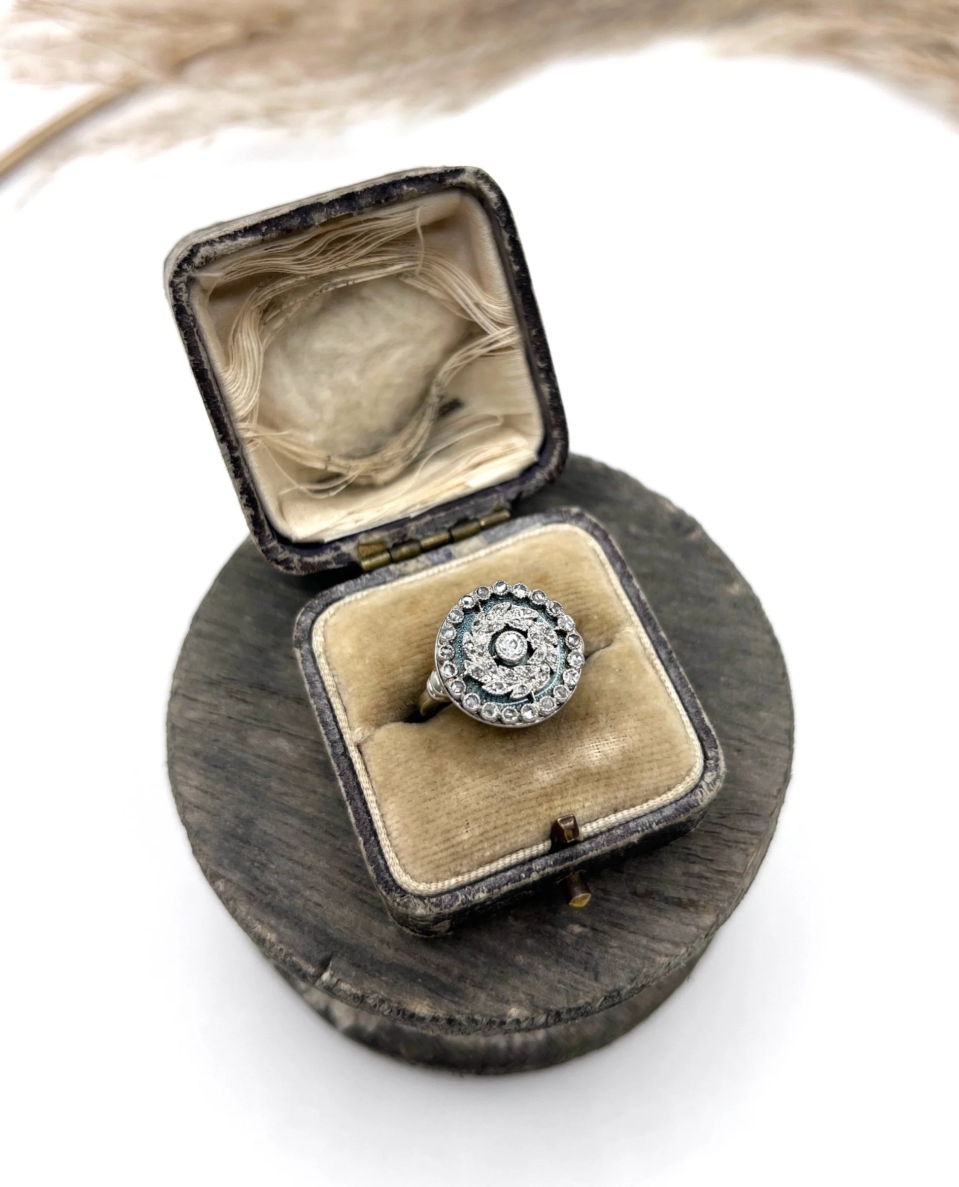 A diamond and dark blue enamel fancy cluster ring in white gold, in an antique ring box