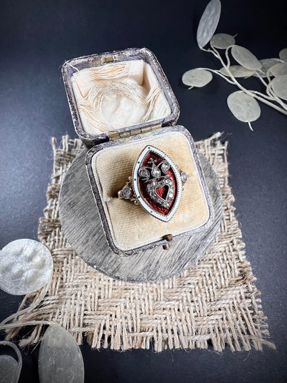 An ornate diamond and enamel navette shaped antique ring, in an antique ring box