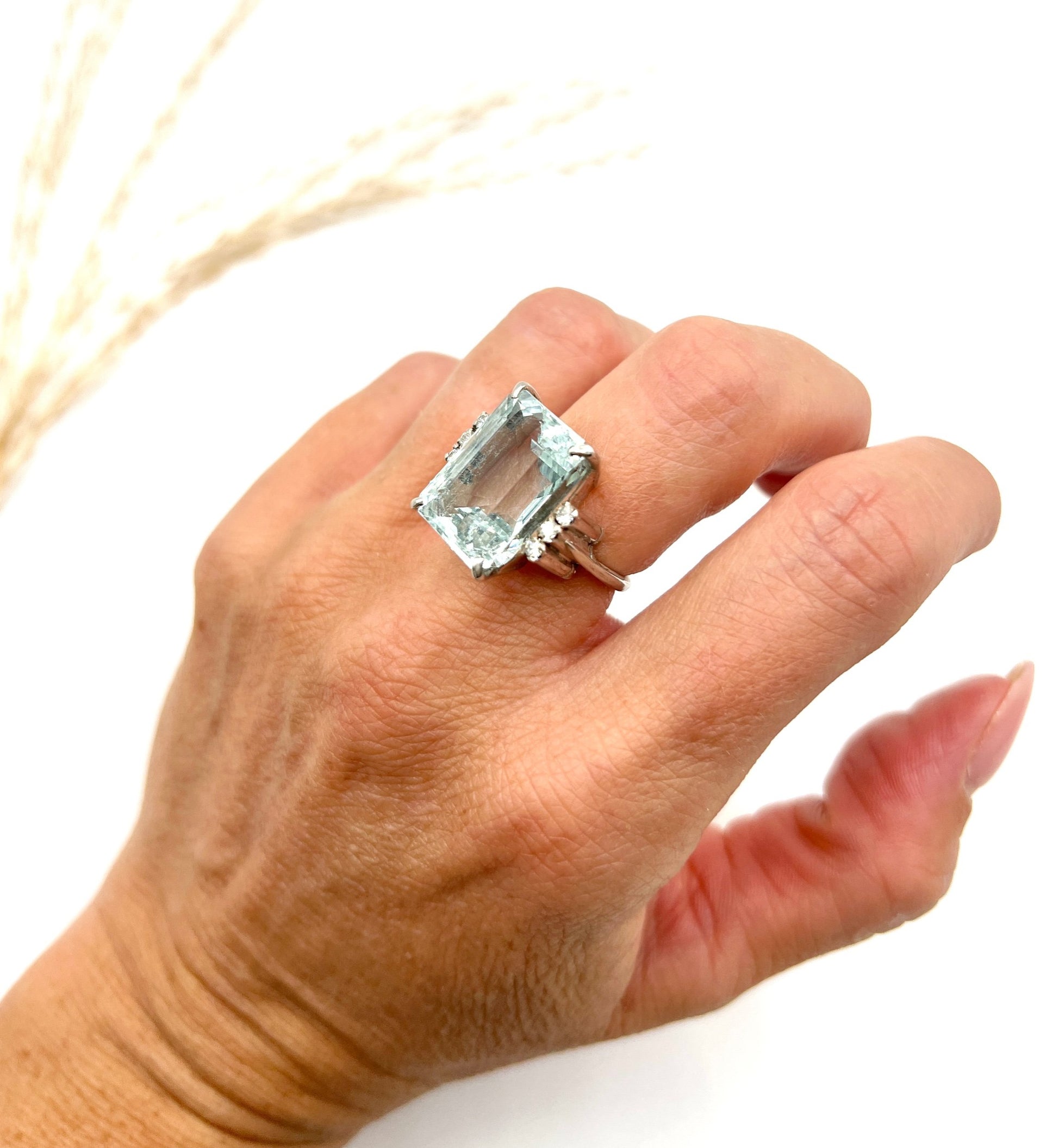 An aquamarine and diamond cocktail ring in white gold, modelled on a hand