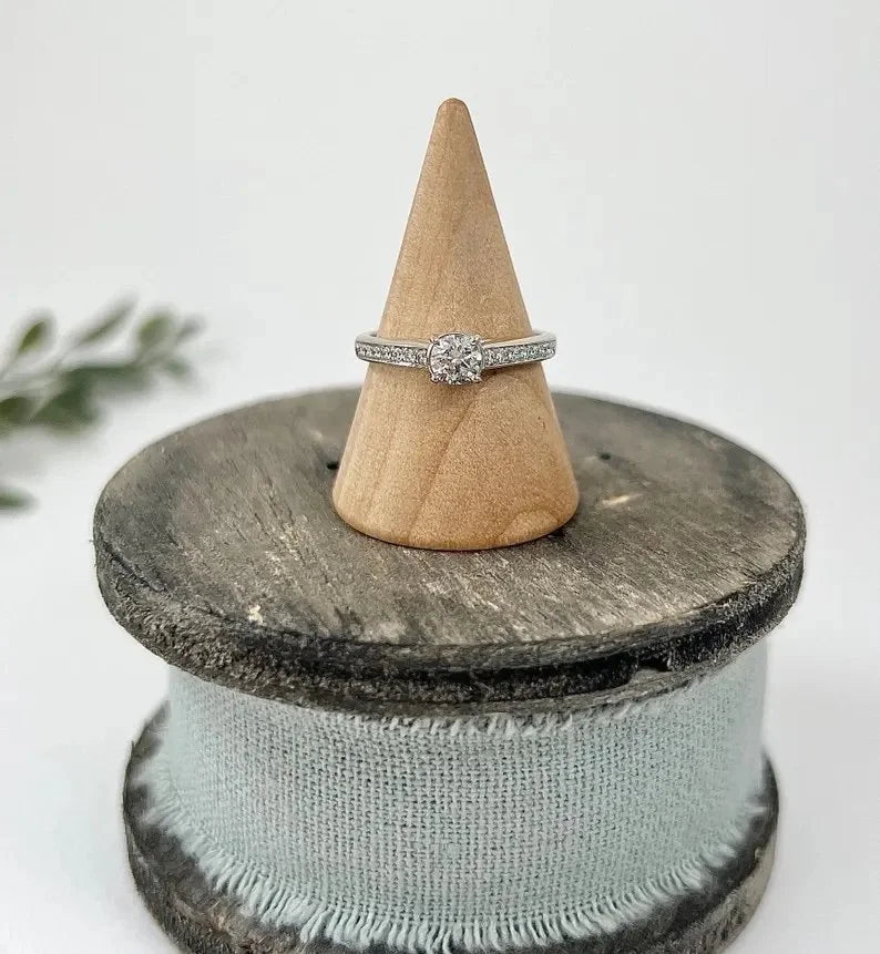 A white gold brilliant cut diamond engagement ring with diamond set shoulders, on a ring cone