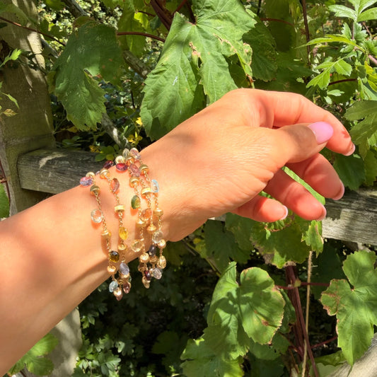 A yellow gold five row multi-gemstone bracelet, modelled on a wrist
