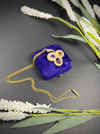 A yellow gold clover pendant with amethyst, citrine, garnet and seed pearls, with a chain
