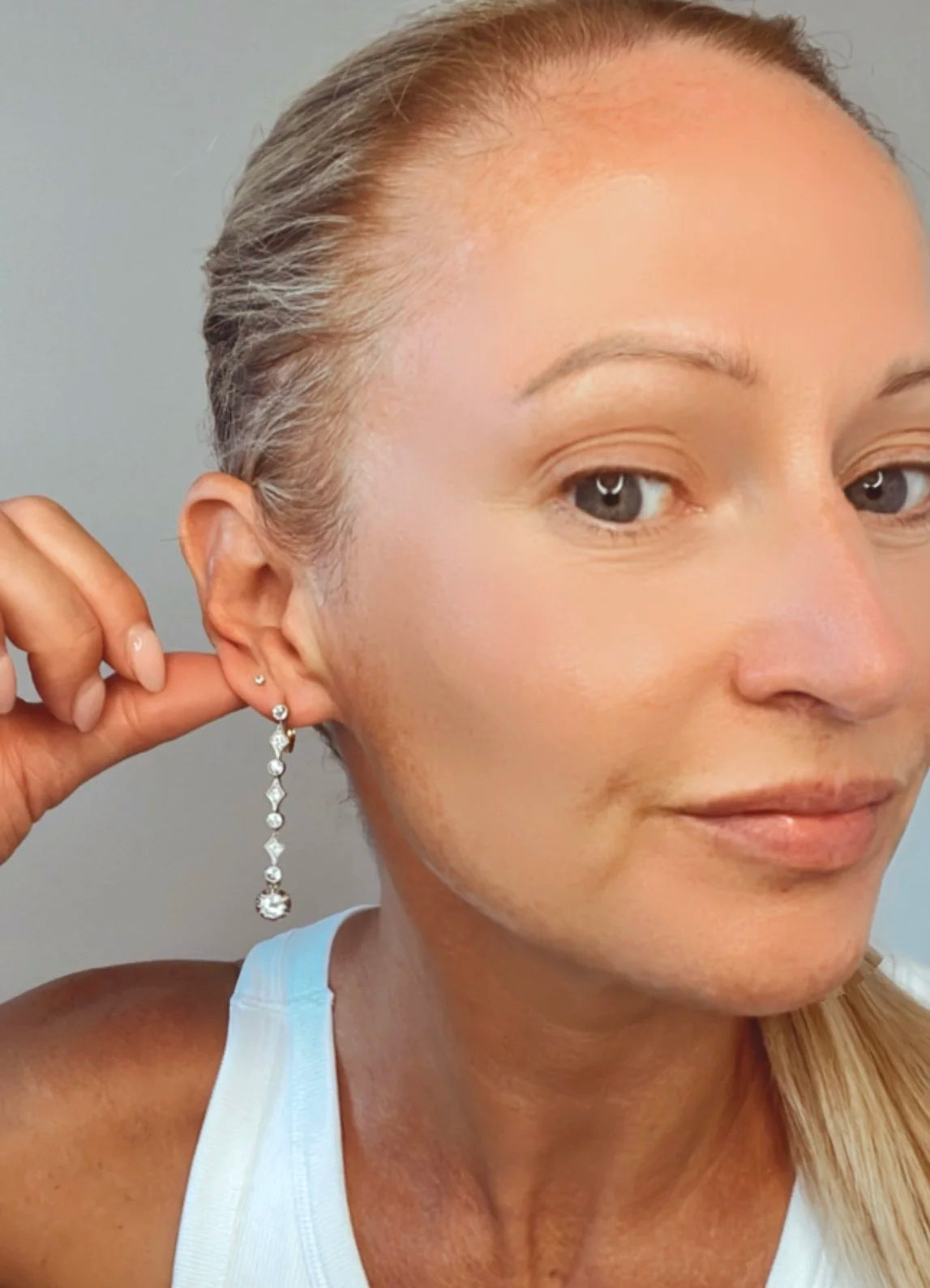 A pair of diamond drop earrings in yellow gold and platinum, modelled in an ear