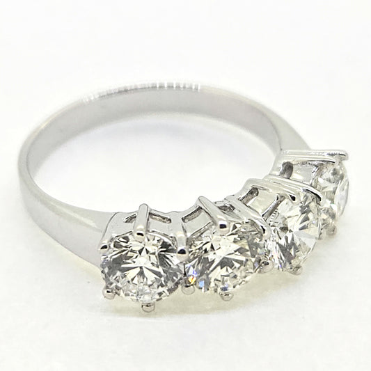 A four stone brilliant cut diamond ring in white gold, on a white background