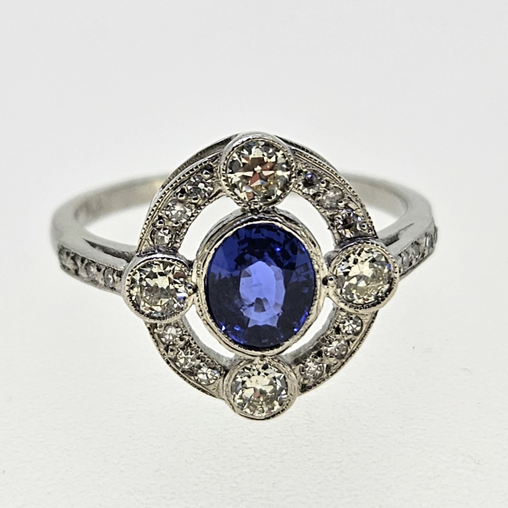 An oval sapphire and round diamond open cluster ring in platinum