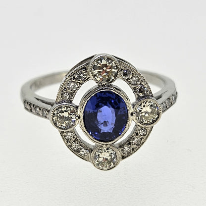 An oval sapphire and round diamond open cluster ring in platinum