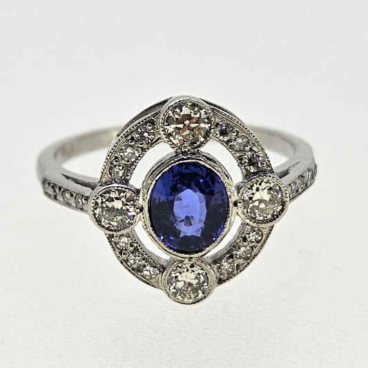 An oval sapphire and round diamond open cluster ring in platinum