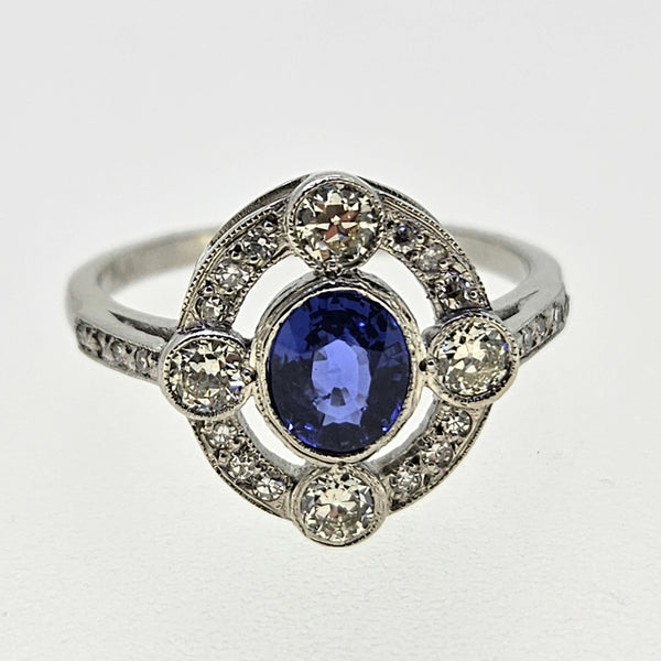 An oval sapphire and round diamond open cluster ring in platinum