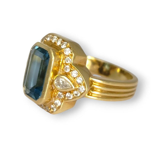 4.4ct Santa Maria Aquamarine and Diamond Cluster Dress Ring, 4.40ct emerald-cut Santa Maria aquamarine flanked by pear-cut diamonds all within diamond border in 18ct yellow gold