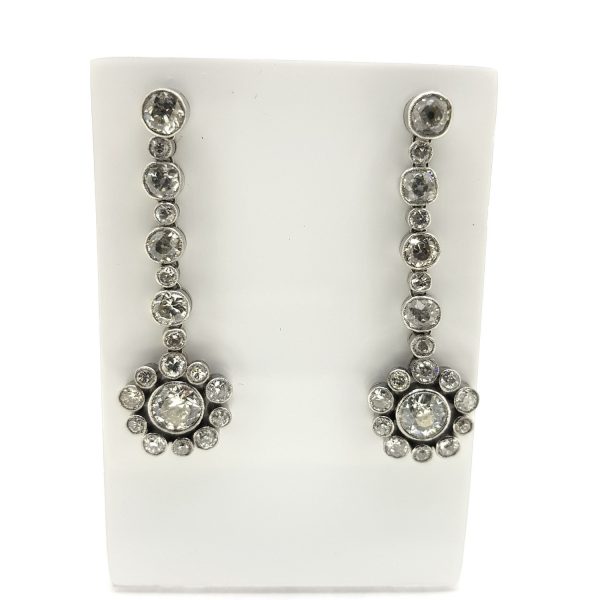 Diamond Flower Cluster Drop Earrings; 6.00 carat diamond drop earrings, diamond floral clusters suspended from diamond set drops comprised of alternating sized diamonds, in 18ct white gold