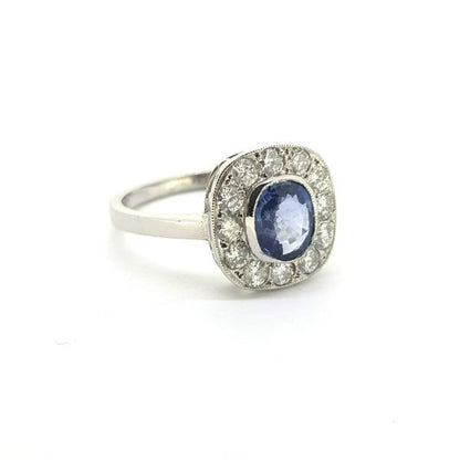 Sapphire and Diamond Cluster Ring; featuring a central 1.10ct oval sapphire surrounded by 0.50cts diamonds, in 18ct white gold