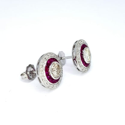 Calibre Ruby and Diamond Target Cluster Earrings; central brilliant-cut diamonds surrounded by calibre-cut rubies, all within outer diamond border, in 18ct white gold