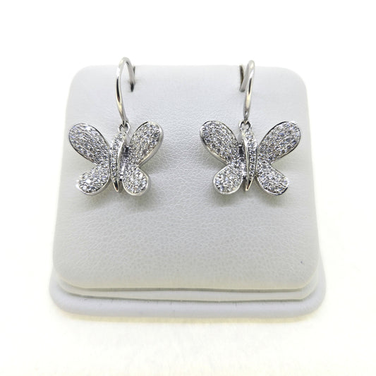 A pair of butterfly shaped diamond set earrings with hook fittings in white gold, on a white background