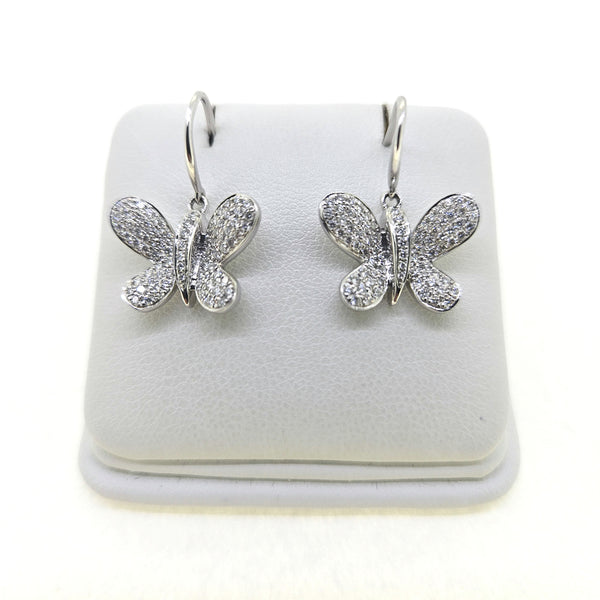 A pair of butterfly shaped diamond set earrings with hook fittings in white gold, on a white background
