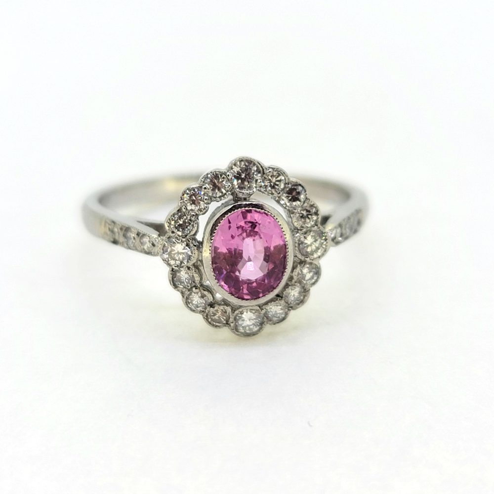 0.80ct Pink Sapphire and Diamond Cluster Engagement Ring in Platinum, 0.80ct oval pink sapphire surrounded by 0.40cts sparkling diamonds in timeless floral cluster design