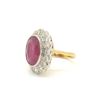 An oval ruby and round diamond scalloped edge cluster ring in yellow and white gold