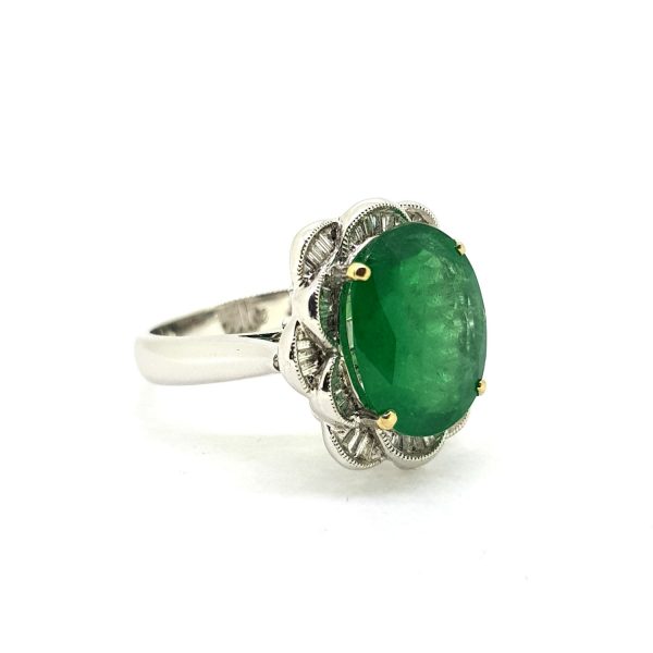 Emerald and Diamond Dress Ring; central 4.9ct oval faceted emerald surrounded by 0.57cts tapered baguette-cut diamond set into petal formation, in 18ct white gold