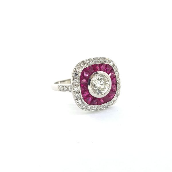 Diamond and Calibre Ruby Cluster Ring; 0.91 carat brilliant-cut diamond surrounded by French cut rubies and outer border of diamonds, in 18ct white gold