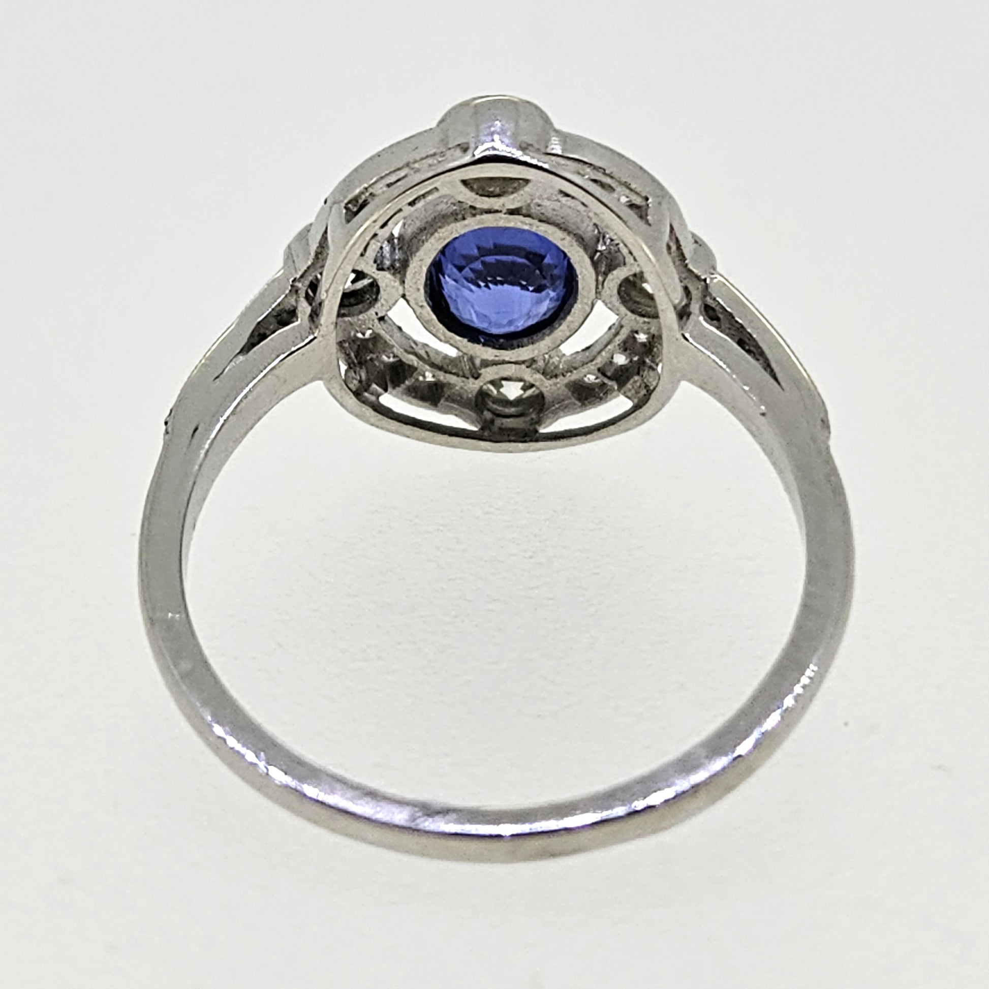 An oval sapphire and round diamond open cluster ring in platinum