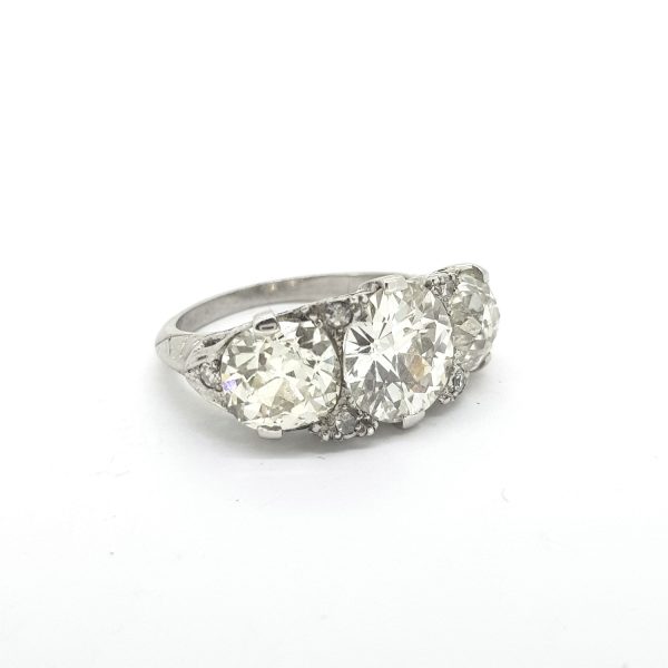 Vintage 1950s Diamond Three Stone Ring, 5.50 carat total, three brilliant-cut diamonds claw-set with delicate diamond accents, in 18ct white gold