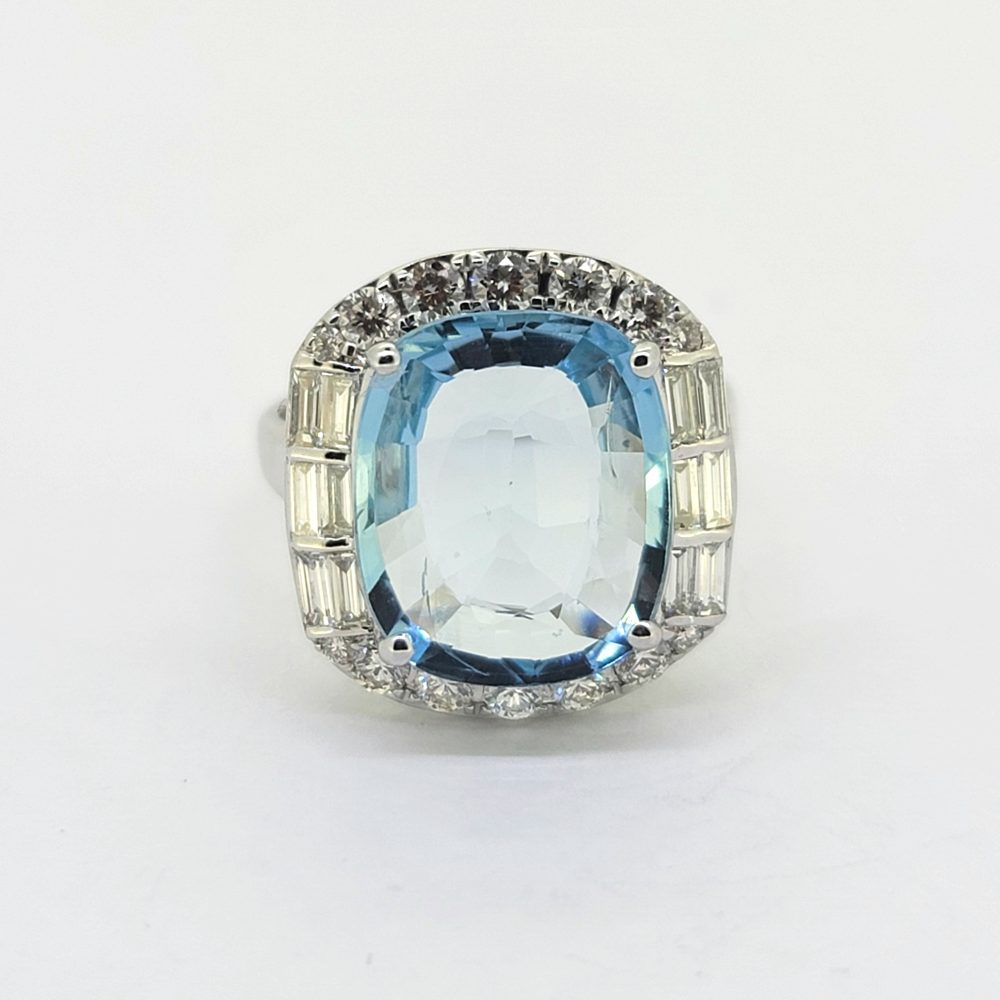 Contemporary 4.64ct Cushion Cut Aquamarine and Diamond Cluster Ring, 4.64ct cushion-shaped aquamarine surrounded by diamonds, with brilliant-cut diamonds to the top and bottom accented with baguette-cut diamonds to the sides in 18ct white gold