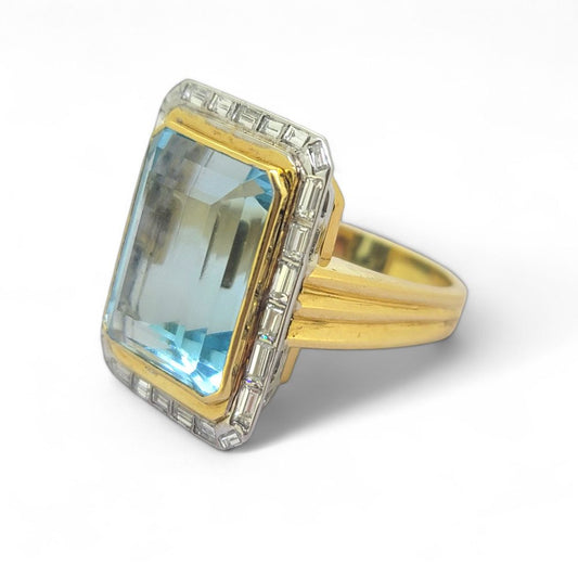 25ct Aquamarine and Baguette Diamond Cluster Ring, large 25cts emerald-shaped step-cut aquamarine bezel set in yellow gold with outer border of baguette-cut diamonds
