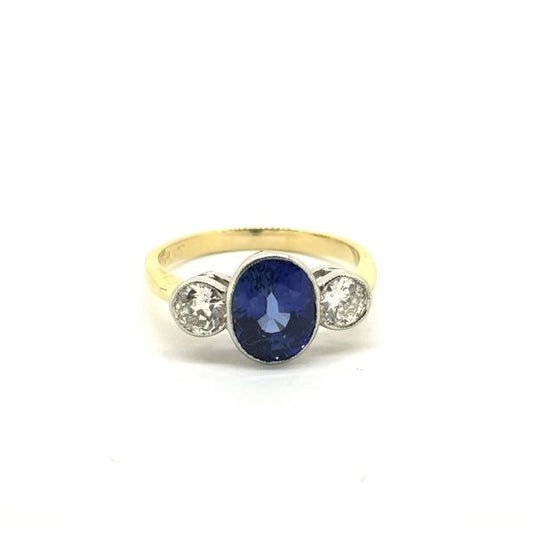 Sapphire and Diamond Three Stone Ring; 2.25ct oval sapphire flanked by 0.65cts brilliant-cut diamonds, in platinum and 18ct yellow gold