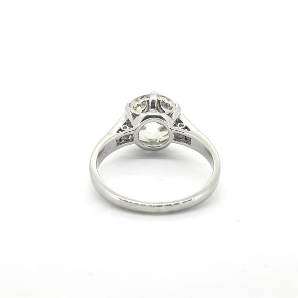 2.87ct Old European Cut Diamond Solitaire Ring in Platinum; single stone 2.87 carat old European-cut diamond, six-claw set, and flanked by a single baguette-cut diamond each side set into straight-up shoulders, platinum openwork under-gallery featuring a heart design